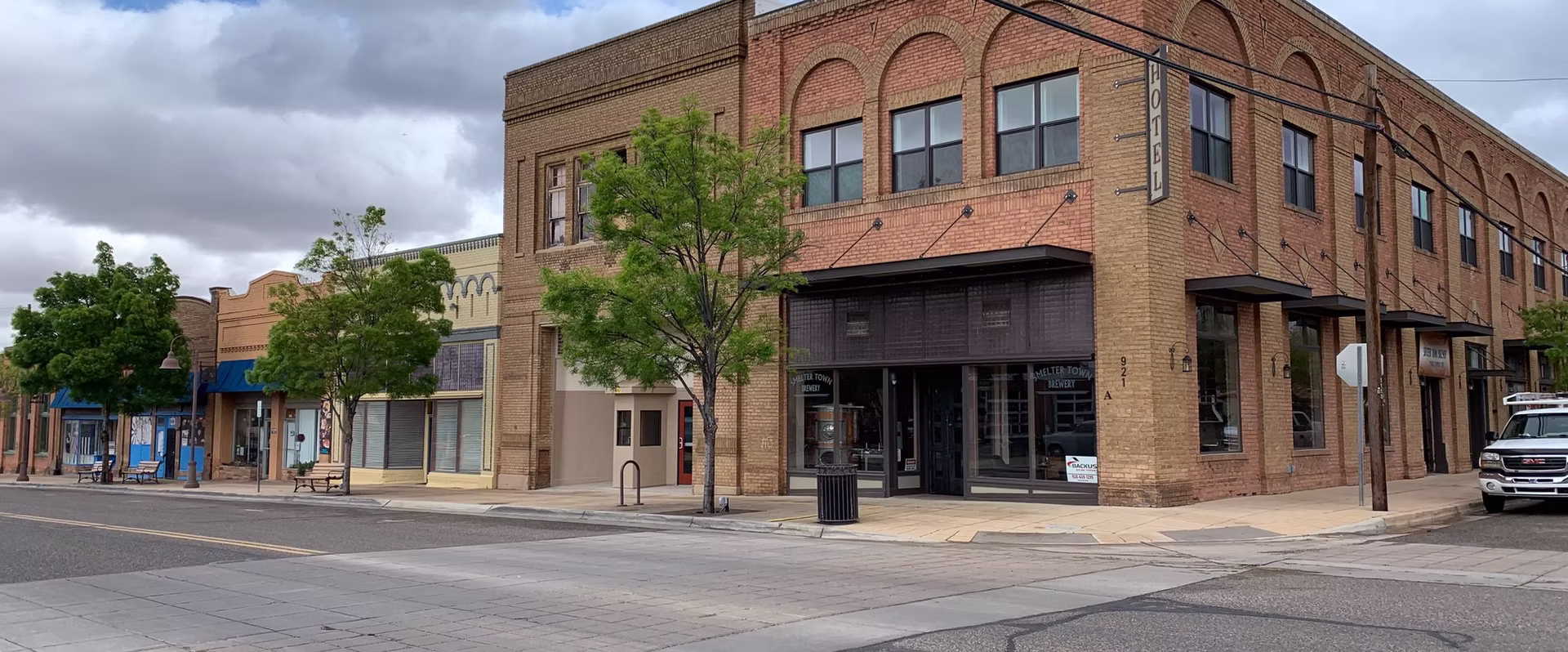 Street corner with brick building and overcast sky.
